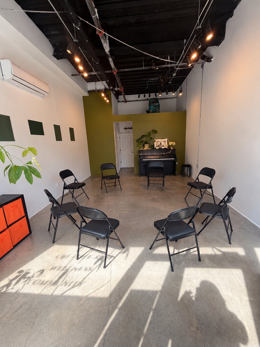 Styled concept of a chair circle beside the upright piano at RISE