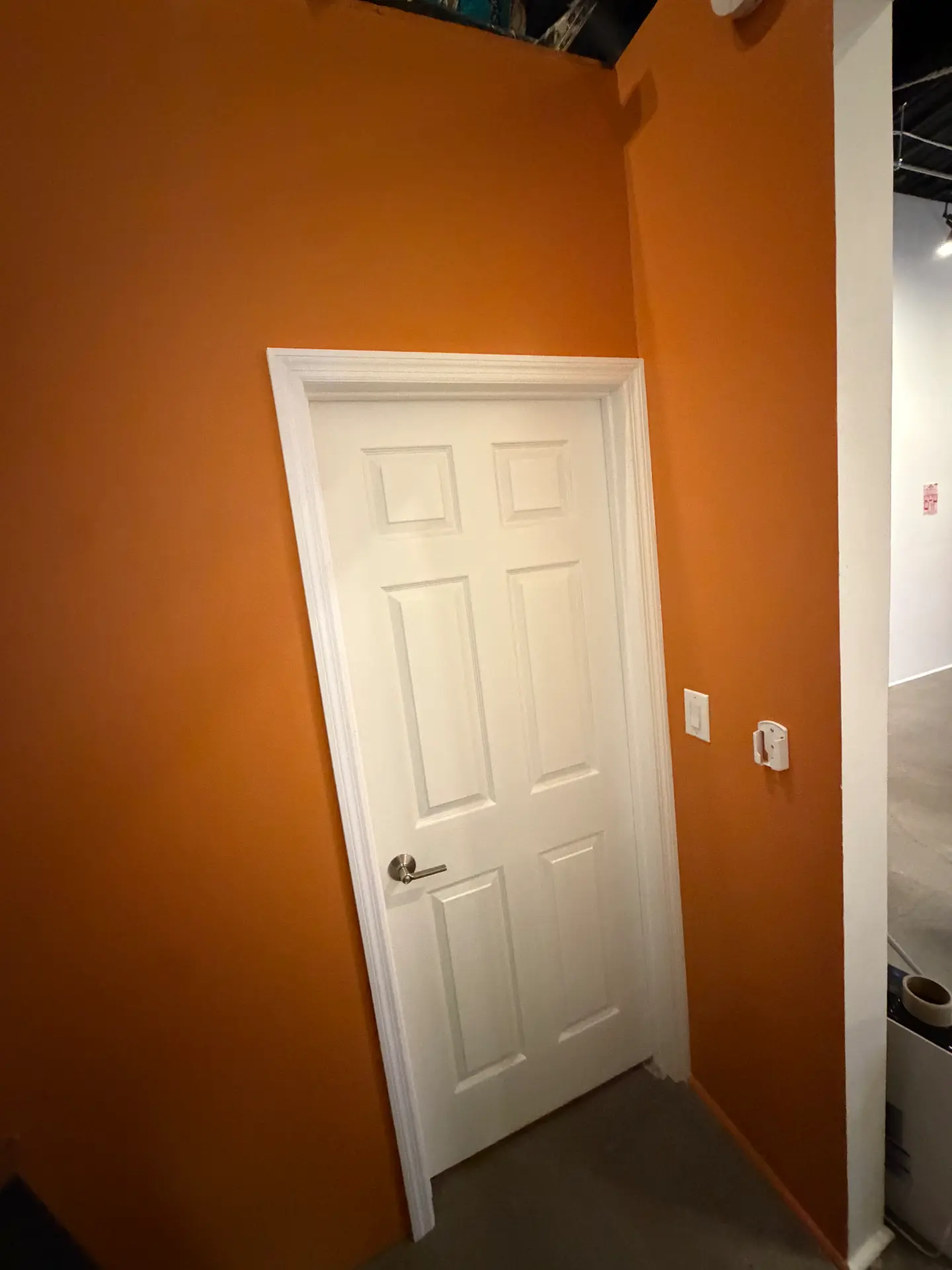 The Orange Room's private closing door set into a deep orange wall